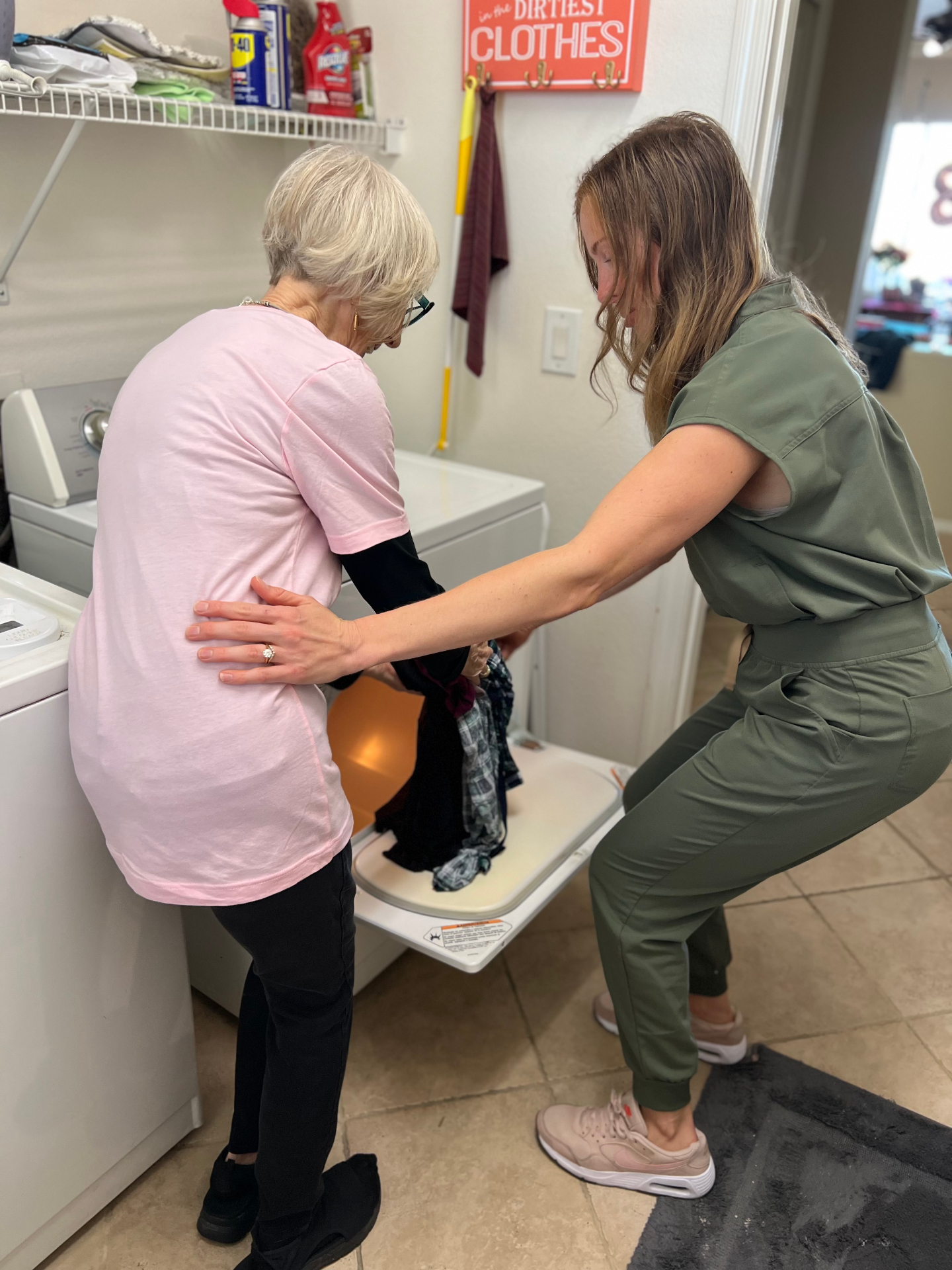 Therapist assisting an older adult with laundry at home
